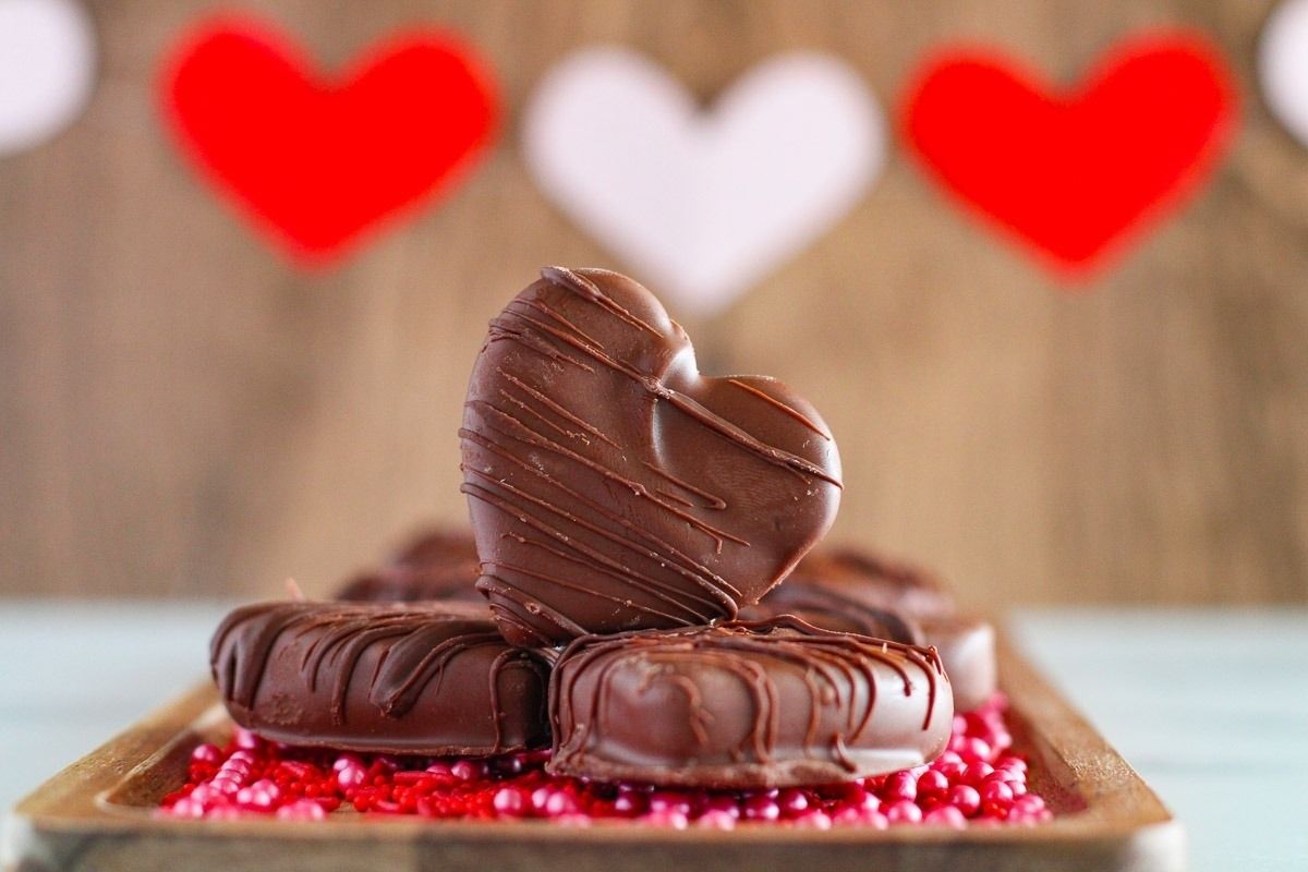 Heart-shaped chocolates on a wooden tray.