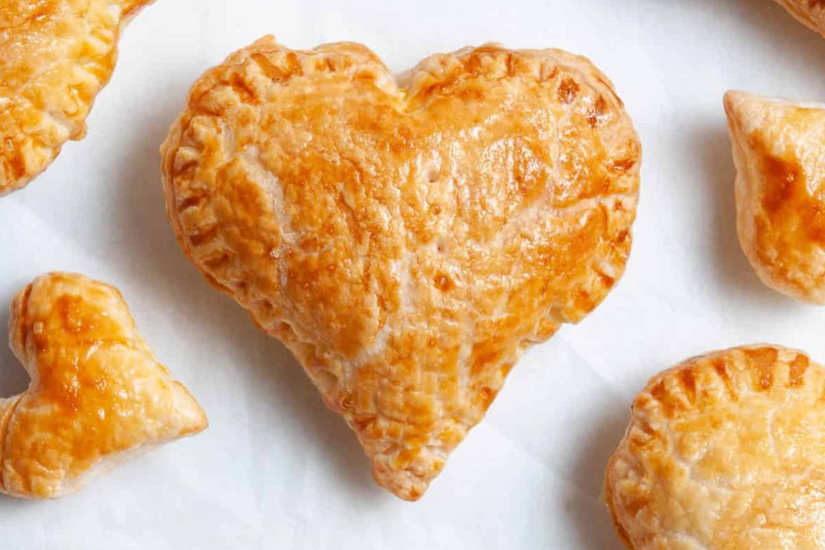 Heart-shaped pastries rest delicately upon a pristine white surface.