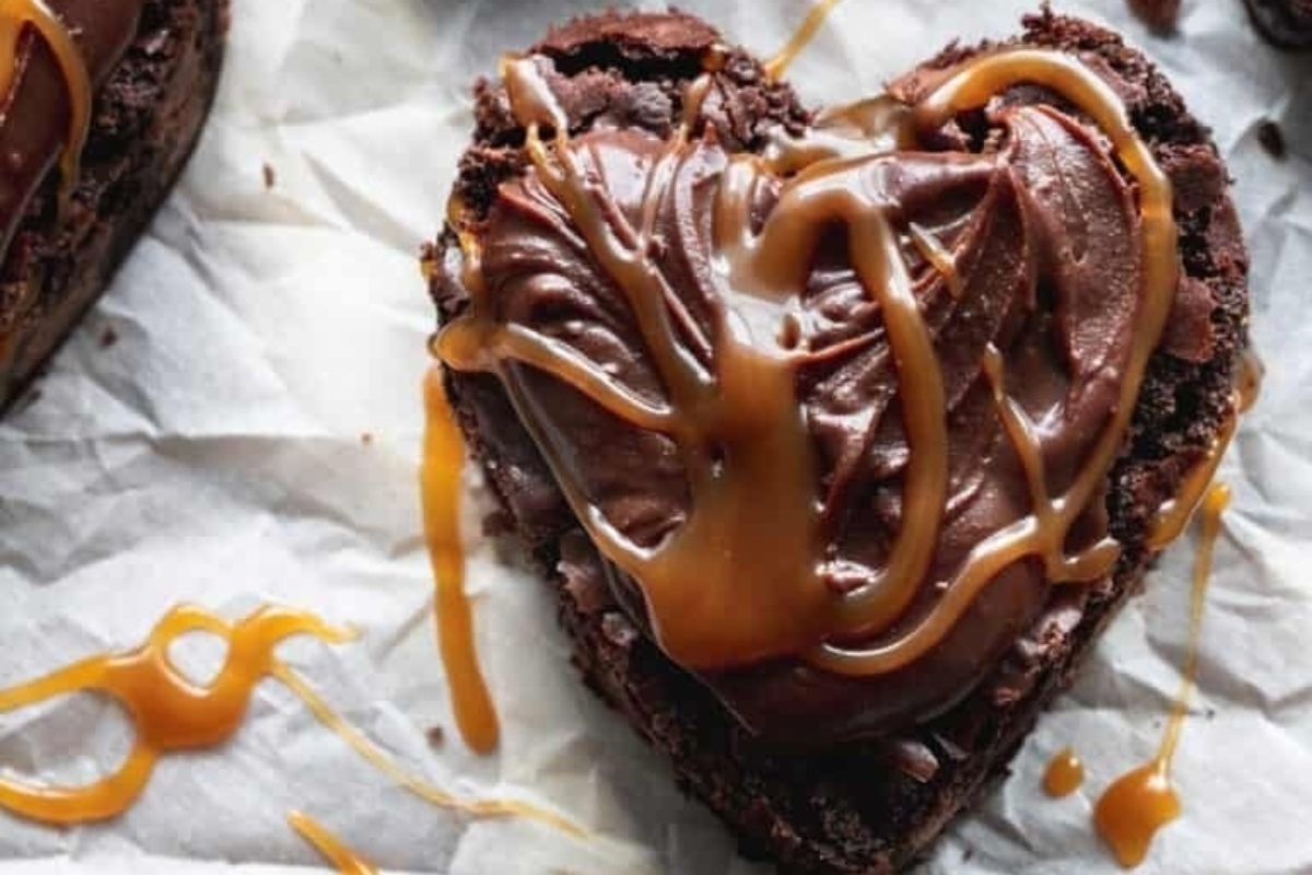 A heart-shaped brownie drizzled with caramel sauce.