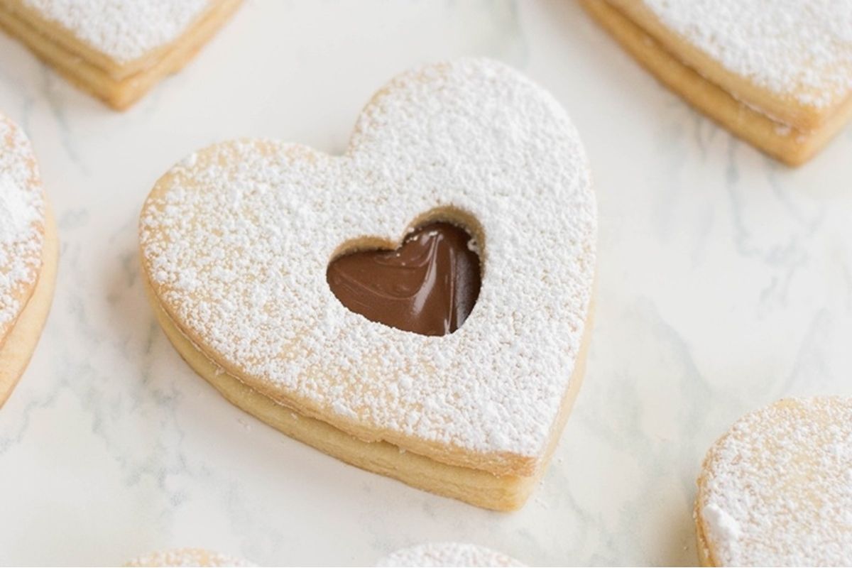 A heart-shaped cookie with chocolate and powdered sugar.