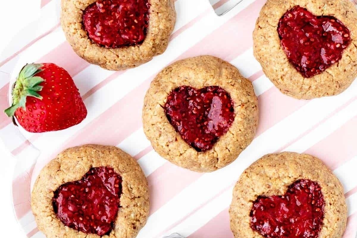 Valentine's day heart-shaped cookies with raspberry jam and strawberries.