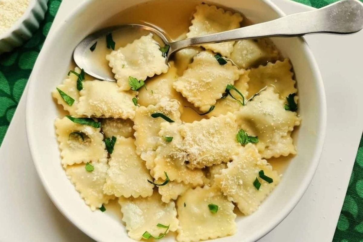 Cheesy ravioli served in a white bowl.