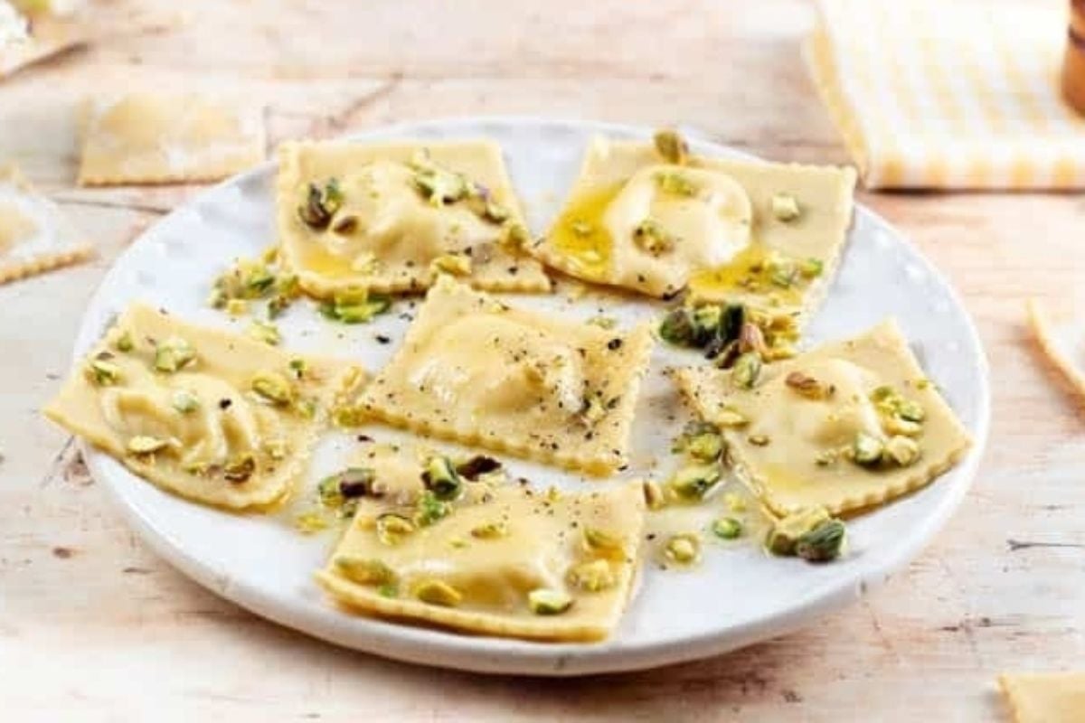 Delicious ravioli on a white plate garnished with pistachios.