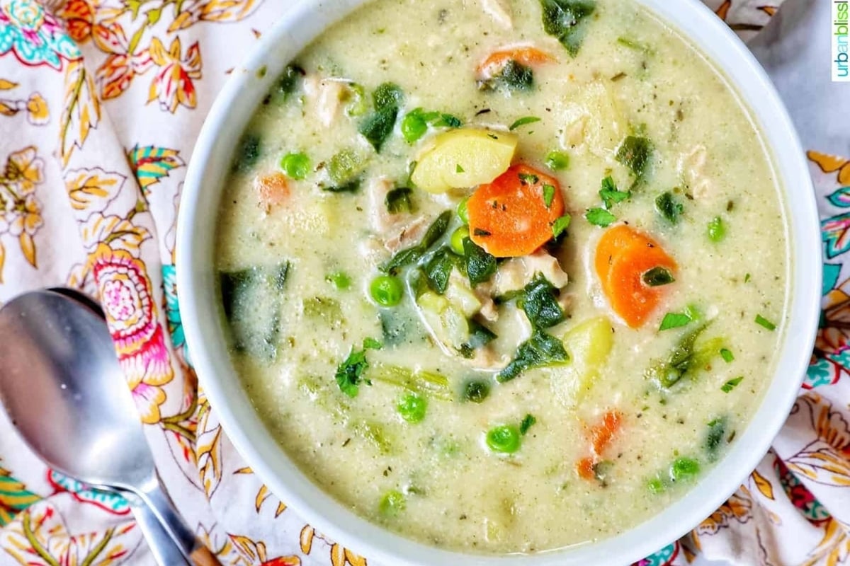A bowl of chicken chowder with carrots and peas, a wholesome twist on traditional chicken soup recipes.