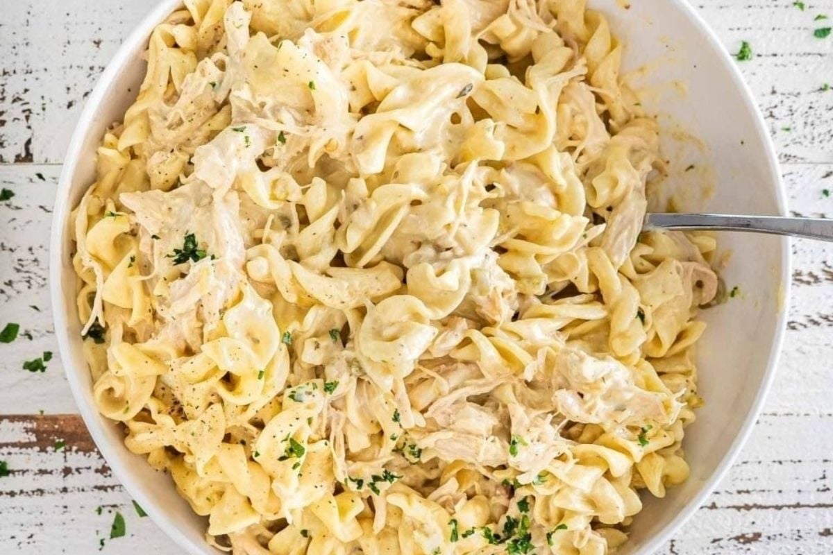 Winter comfort food - chicken pasta served in a white bowl with a spoon.