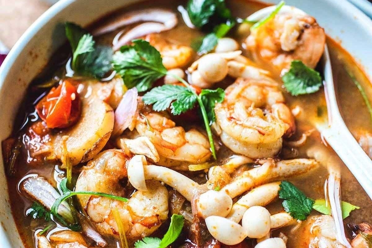 A winter bowl of shrimp and bean soup with a spoon.