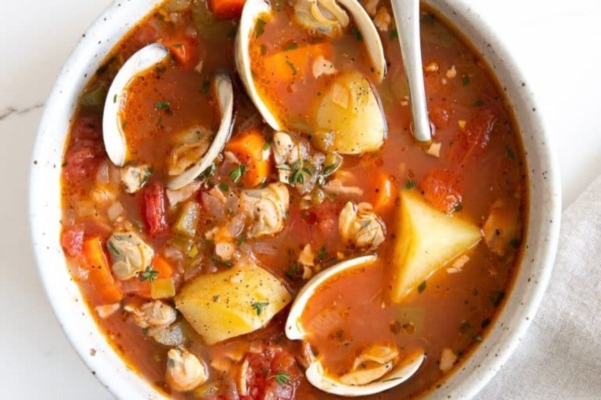 Try out this delicious chowder recipe - a bowl of clam and potato soup with a spoon.