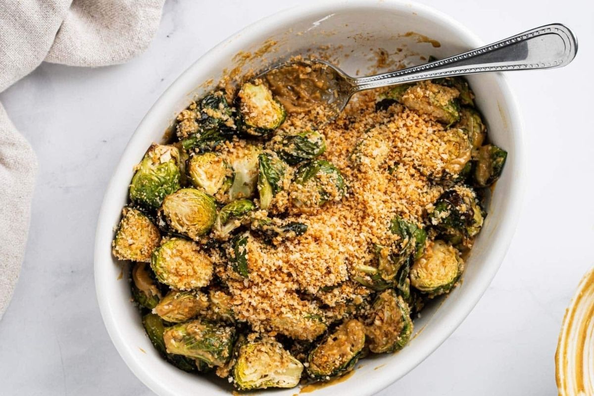 Wholesome Brussels sprouts in a white bowl with a spoon.