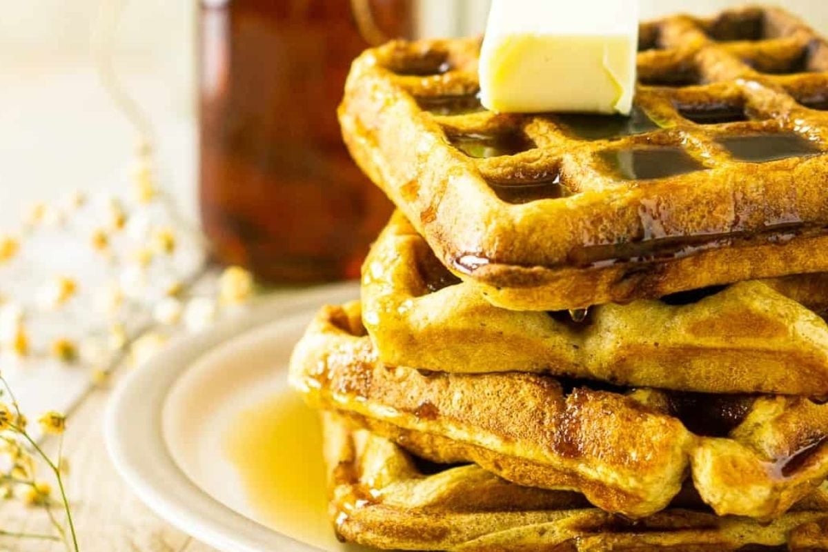 A stack of waffles with butter and syrup, perfect for breakfast.