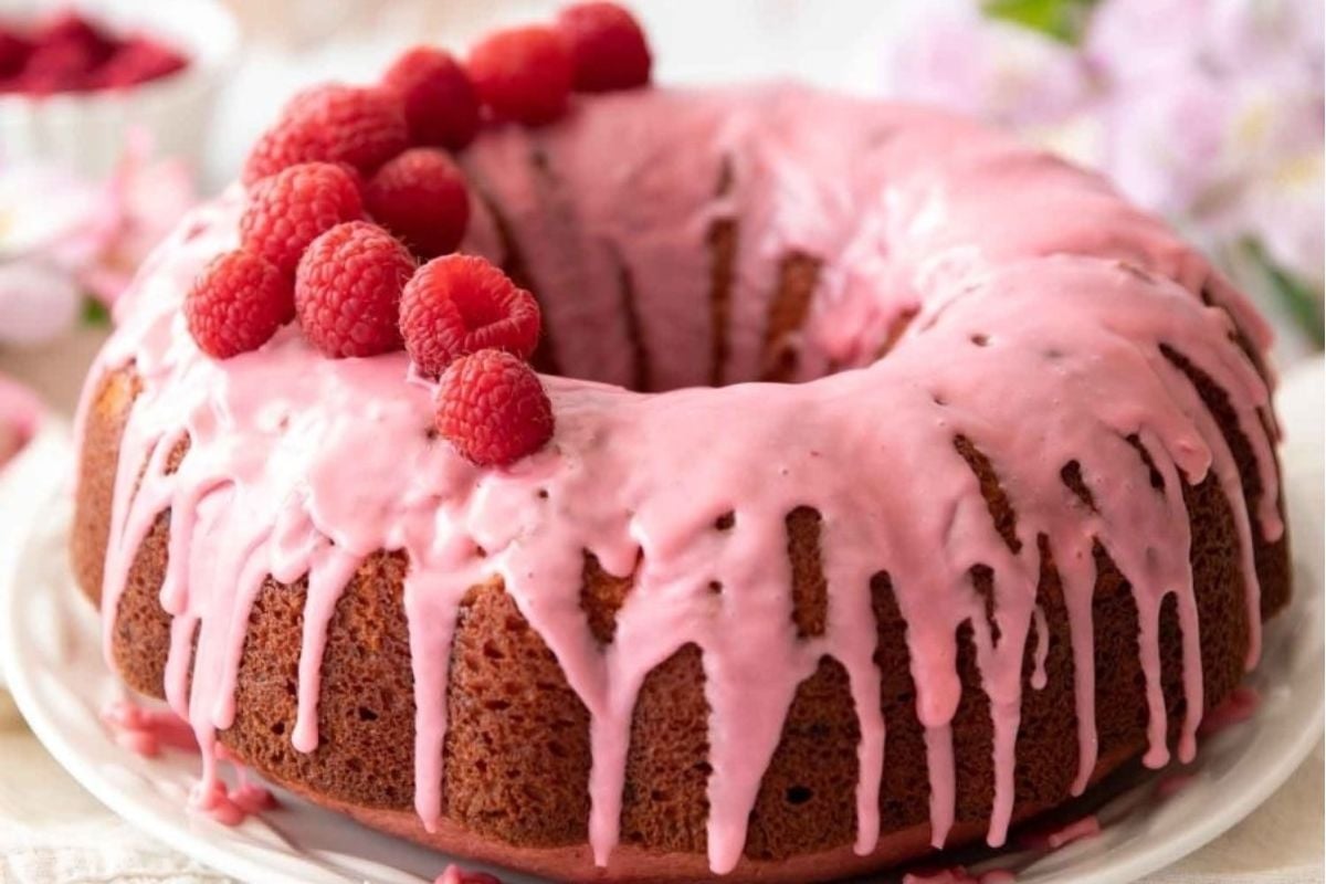 Valentine's desserts: A pink bundt cake with icing and raspberries, perfect for a romantic celebration.