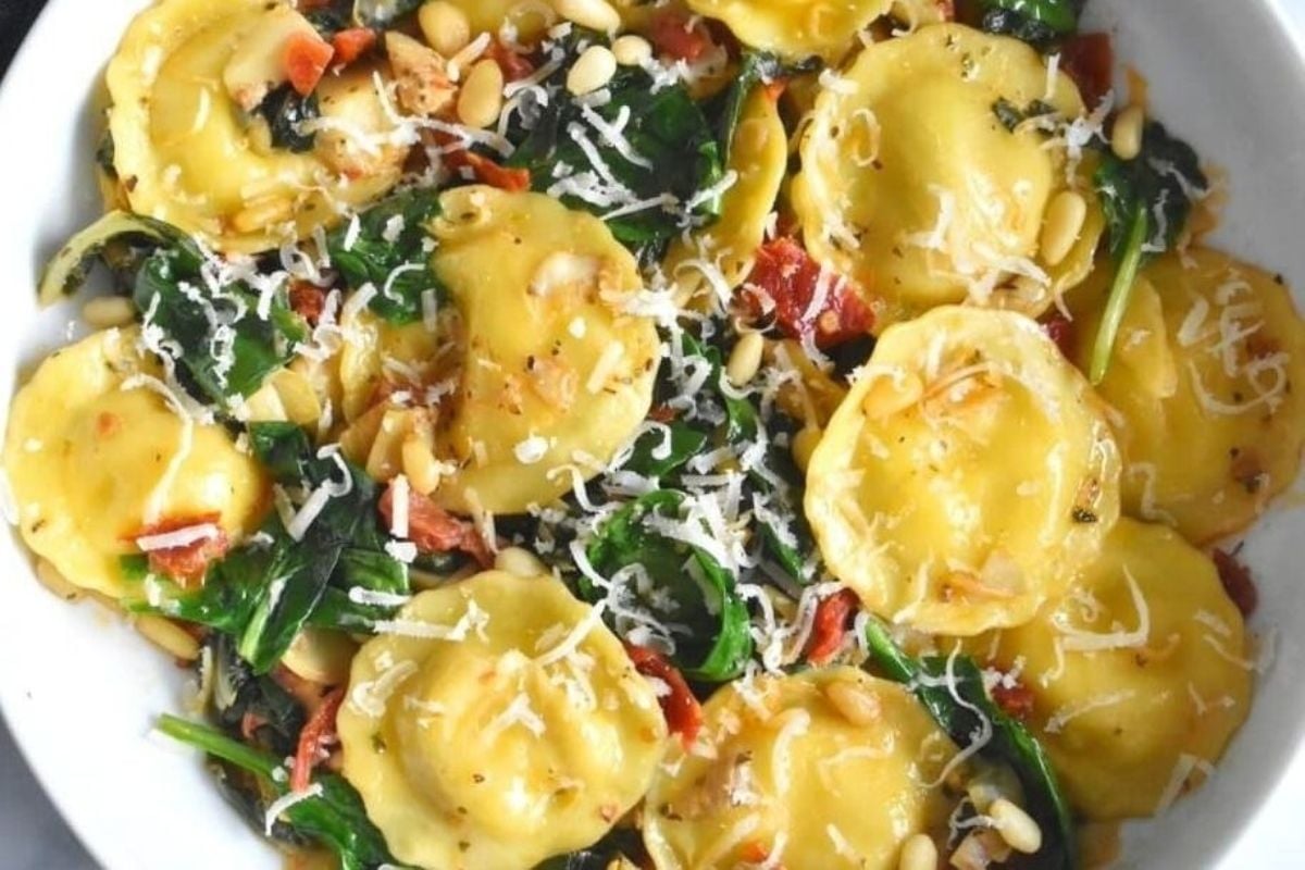 Check out this delicious spin on ravioli recipes - filled with spinach and pine nuts, served in a white bowl.