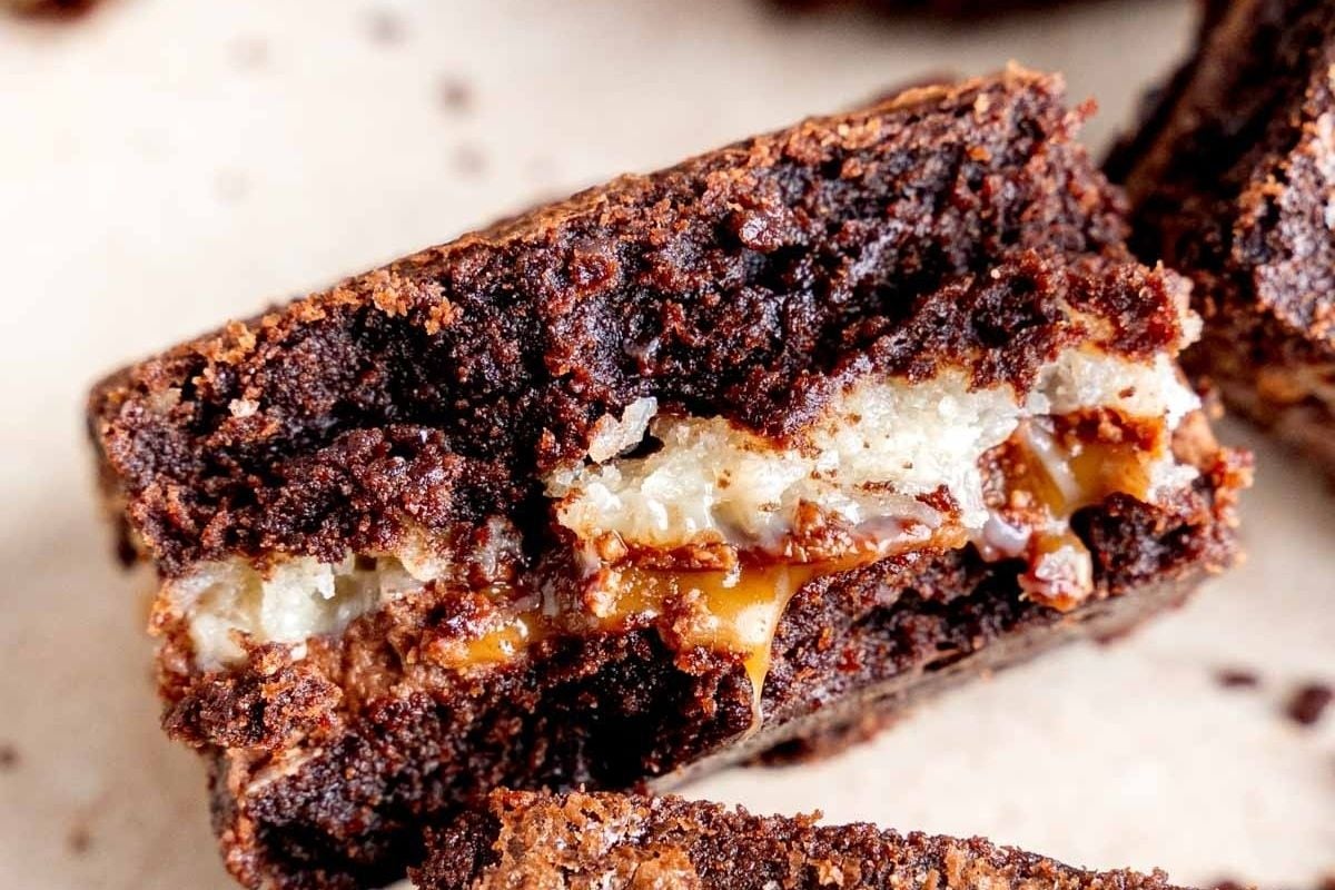 A close up of decadent chocolate brownies with a luscious caramel filling.