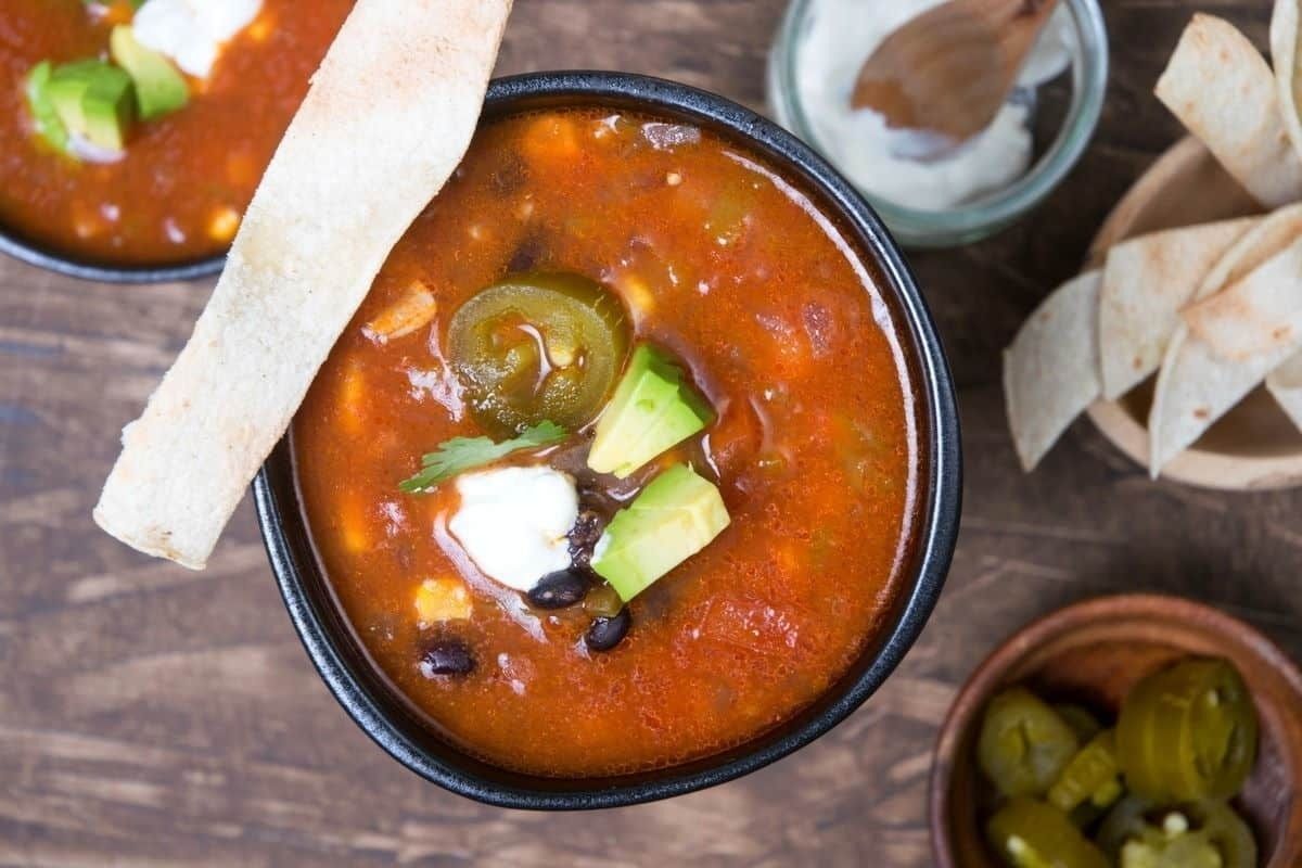 A wholesome Mexican soup, slow-cooked to perfection, served with crispy tortilla chips and a side of creamy guacamole.