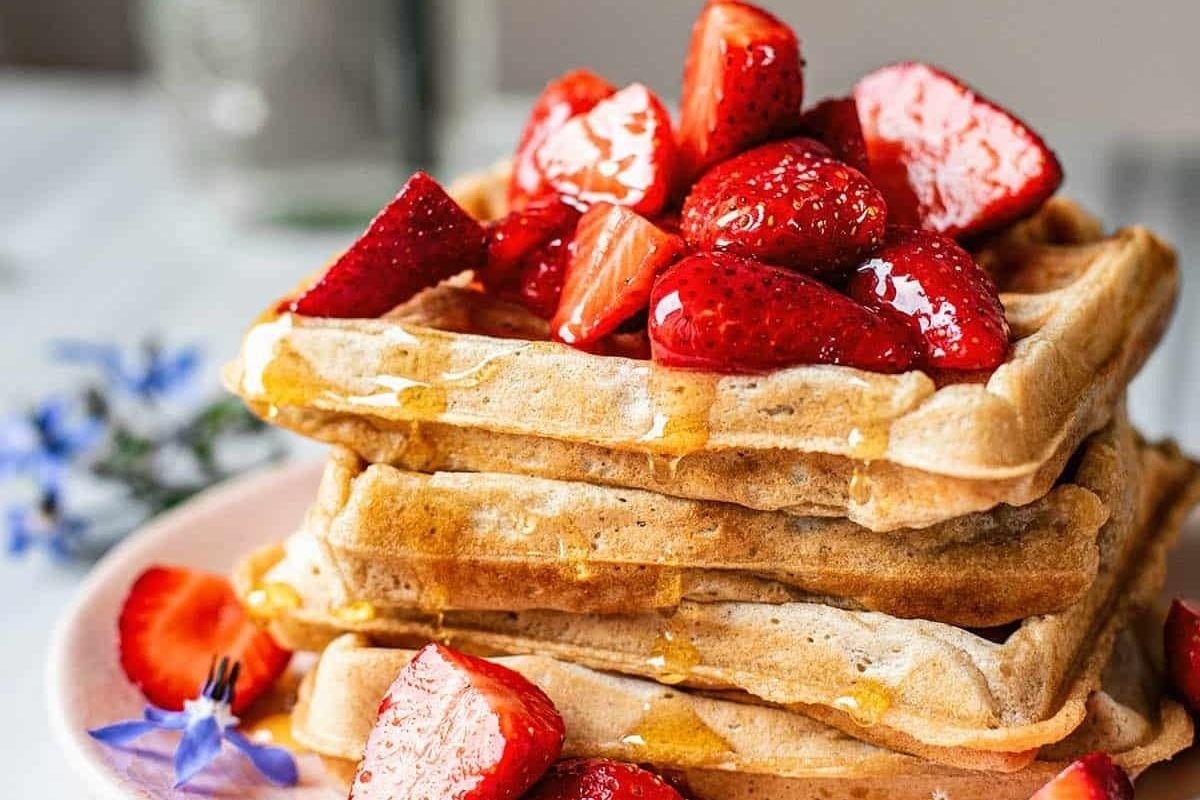         Description: A stack of DELICIOUS waffles with strawberries and syrup.