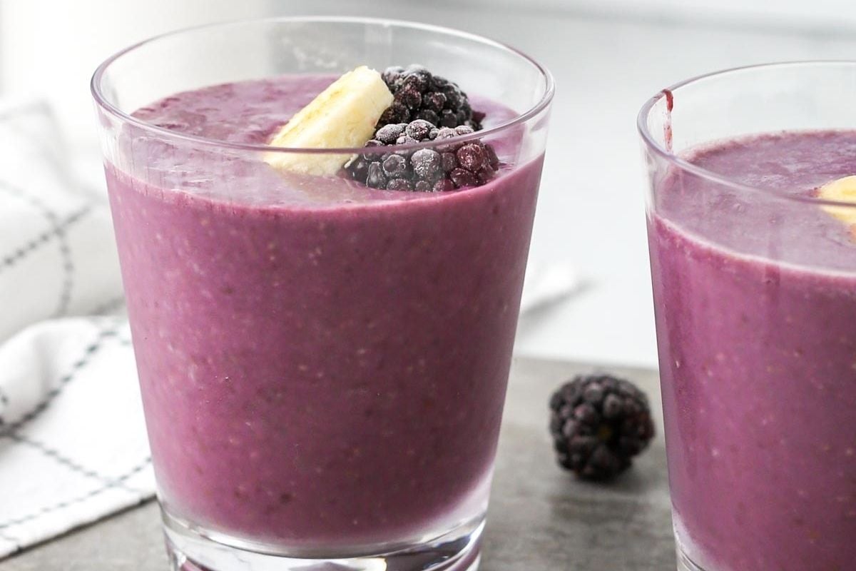 Two glasses of smoothie with blackberries, bananas, and inspired by pinwheel recipes.