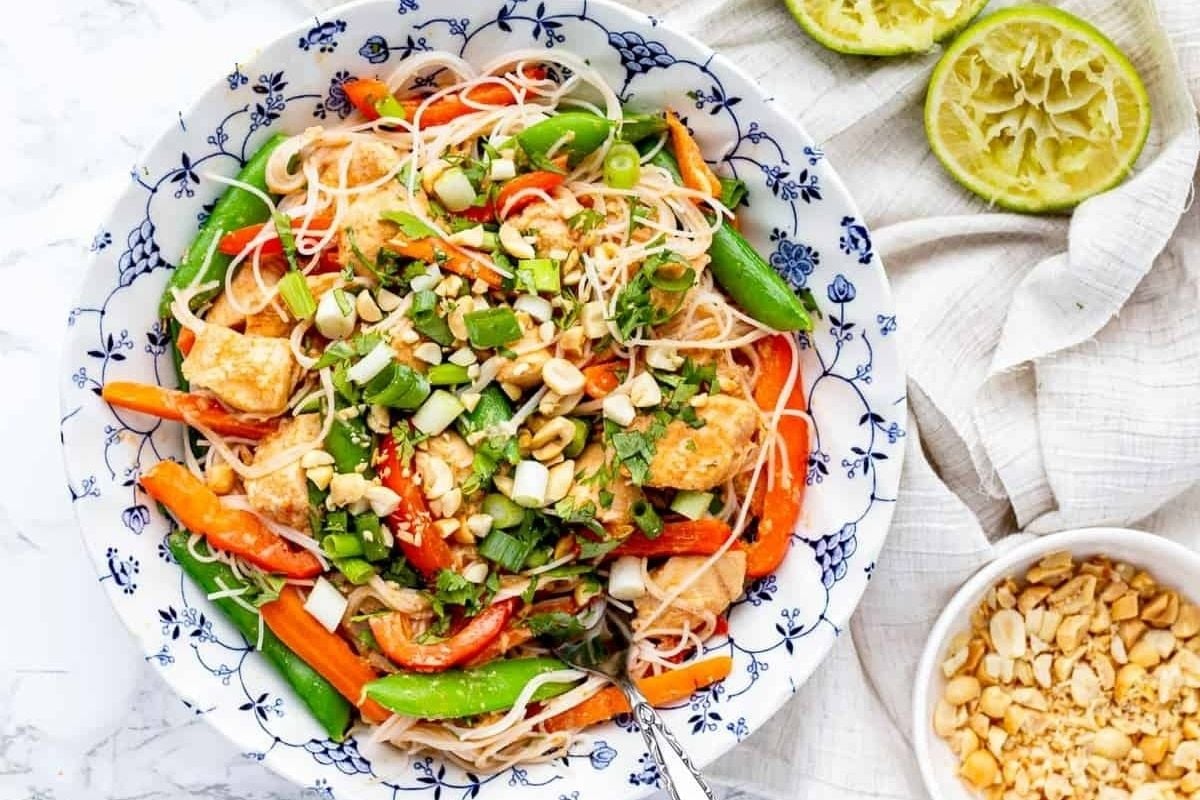 A wholesome bowl of Thai noodle salad with carrots and peanuts.