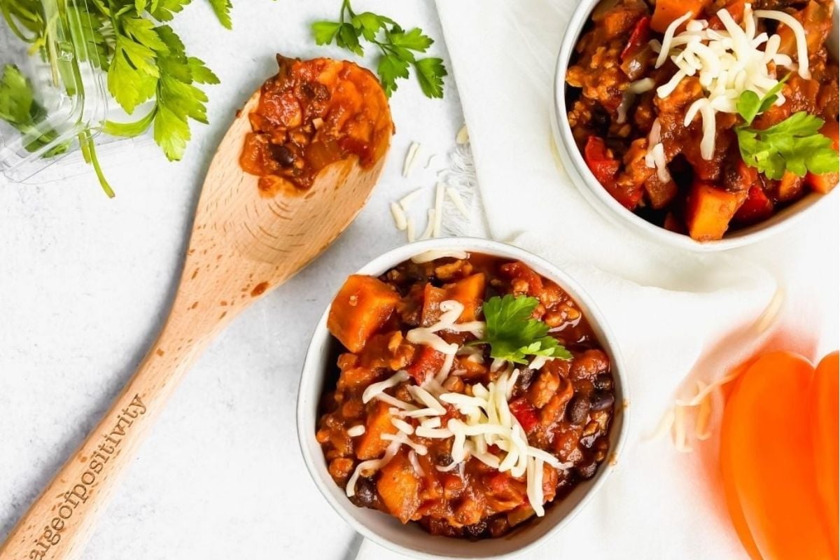 Two wholesome bowls of slow-cooked chili with cheese and parsley.