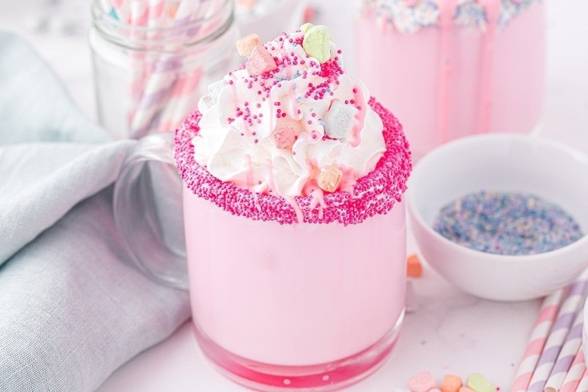 A pink milkshake with sprinkles and whipped cream, perfect for those looking for pink recipes.