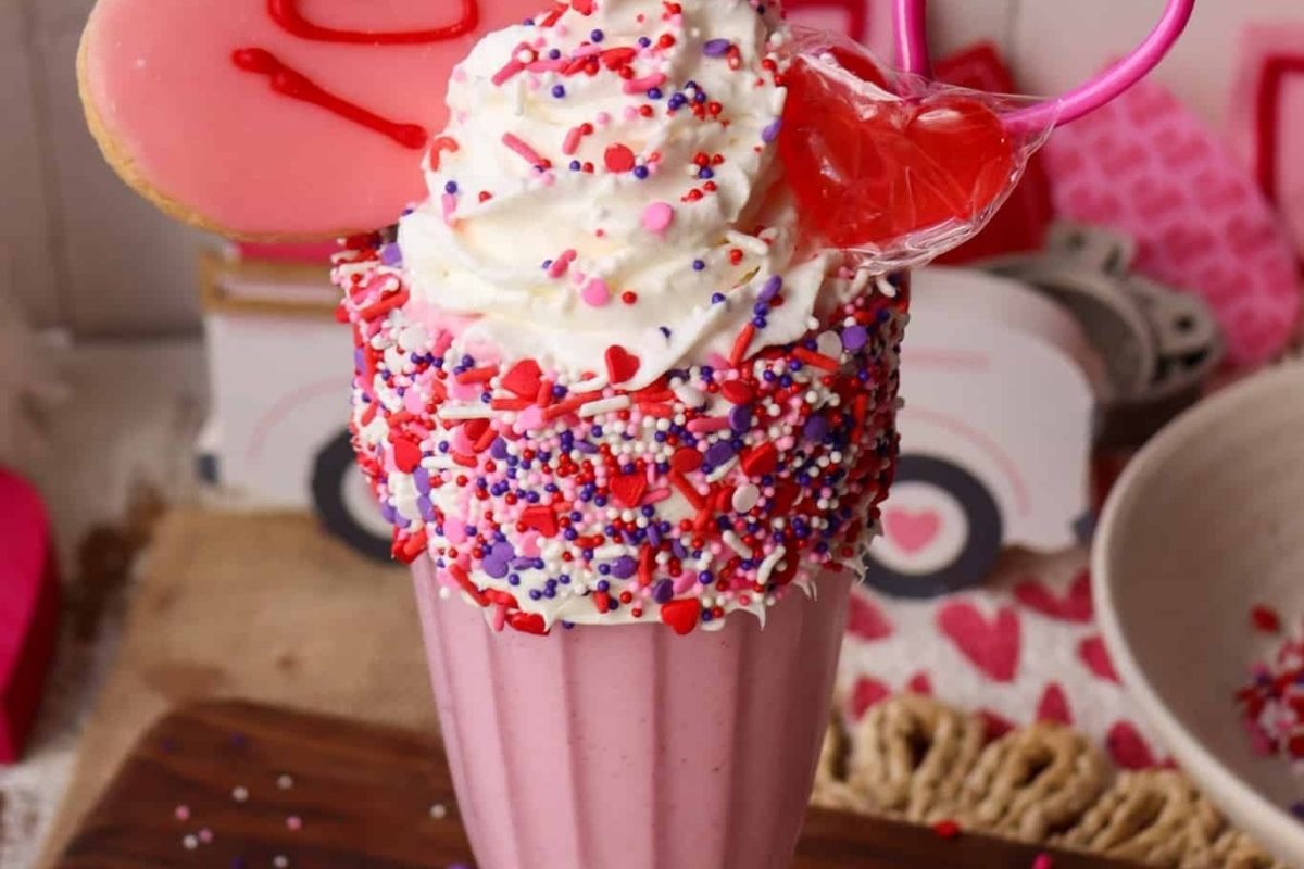 A delightful Valentine's Day milkshake adorned with sprinkles and cookies, perfect for indulging in romantic desserts.