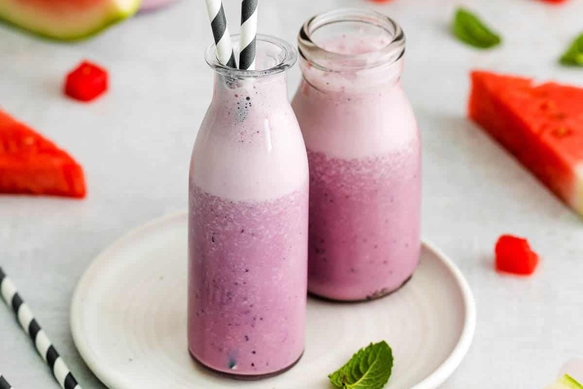 Two bottles of watermelon smoothie on a plate, accompanied by pinwheel recipes.