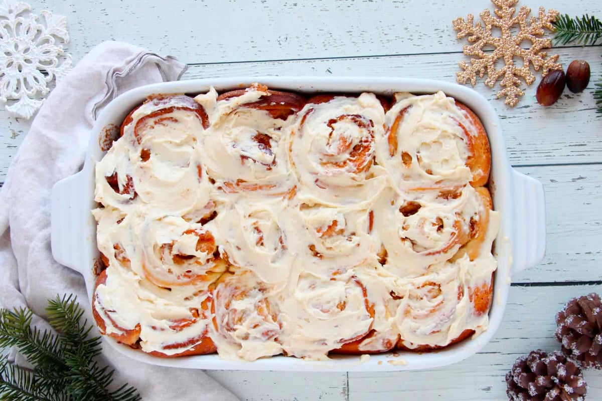 Delicious cinnamon rolls in a white dish with mouthwatering icing. Get the best cinnamon roll recipes here!
