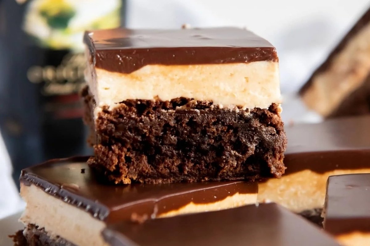 Irish cream brownies on a plate with a bottle of Irish cream, perfect for St Patrick's treats.