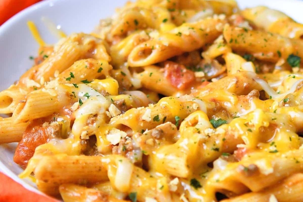A bowl of taco-flavored pasta with meat and cheese.