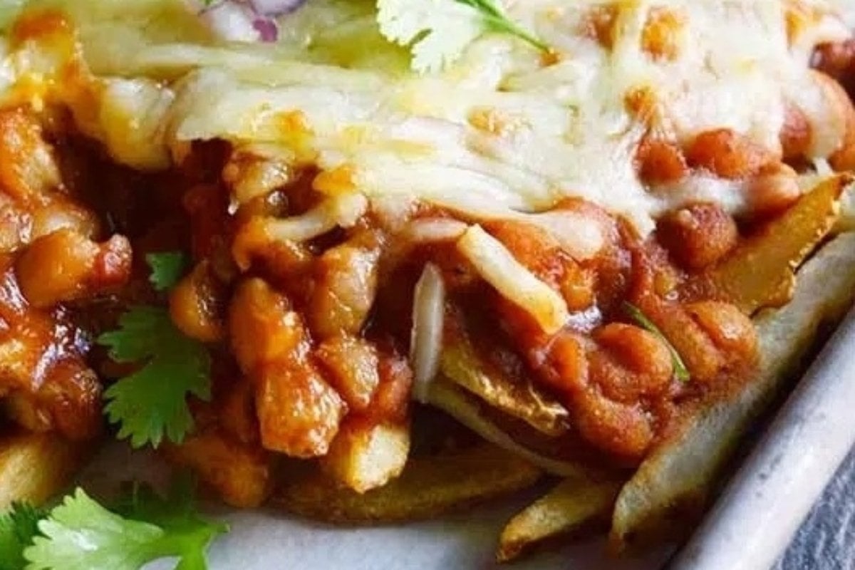 Plate of chili cheese fries topped with melted cheese and garnished with parsley, a classic from comfort food recipes.