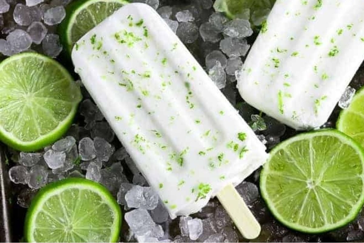 Tangy lime popsicles paired with fresh lime slices on a bed of ice, perfect for citrus lovers.