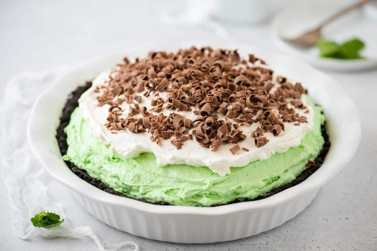 Indulge in a creamy mint ice cream pie served in a white dish.