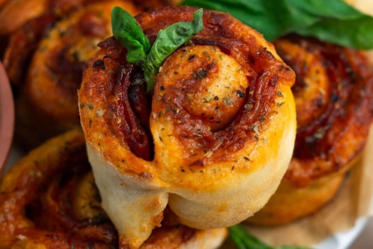 A plate of pizza rolls with basil leaves on it is a girl's dinner.