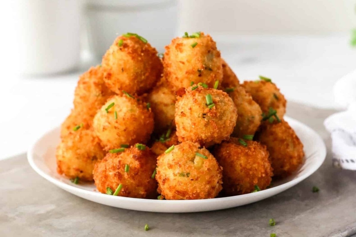 A stack of fried cheese balls on a girl's dinner plate.