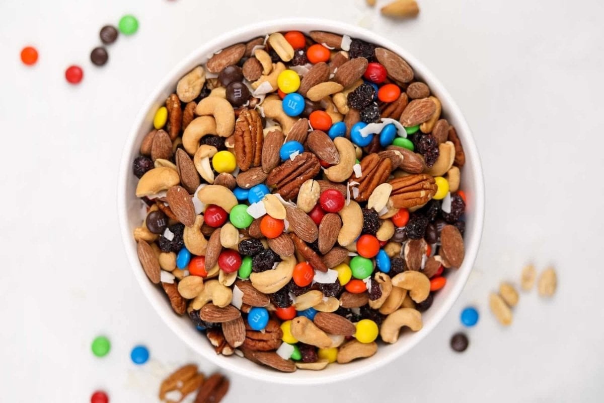 A girl enjoys a bowl full of mixed nuts and M&Ms for dinner.