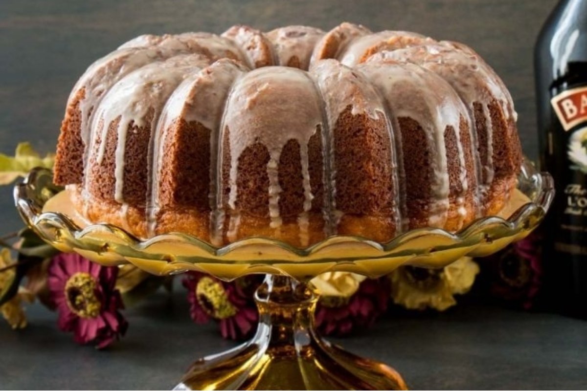 A St Patrick's bundt cake with icing and a bottle of Bailey's.
