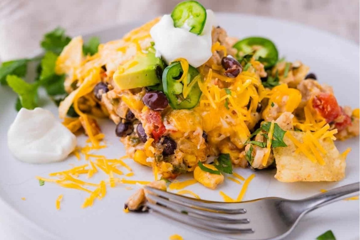 Mexican taco flavored chicken casserole on a white plate with a fork.