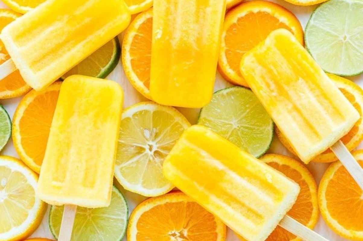 Citrus popsicles featuring oranges and limes against a white background.