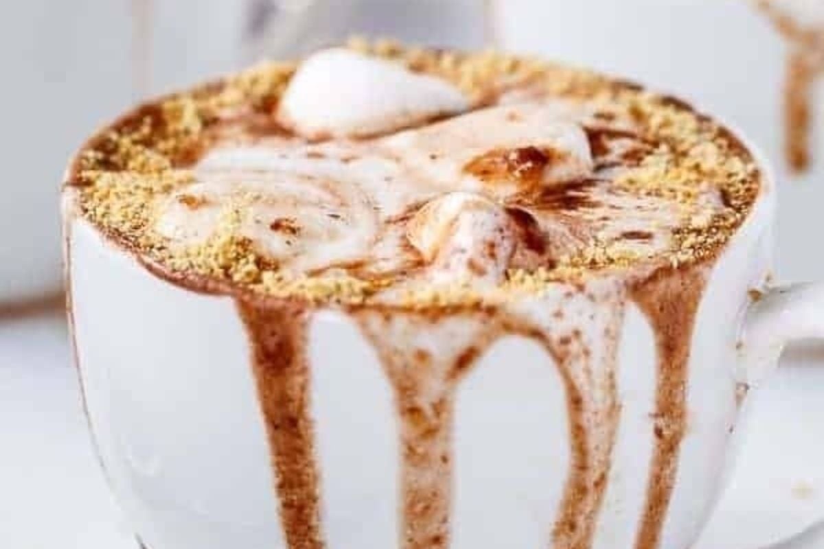 A cup of hot chocolate with marshmallows, whipped cream, and chocolate peanut butter.