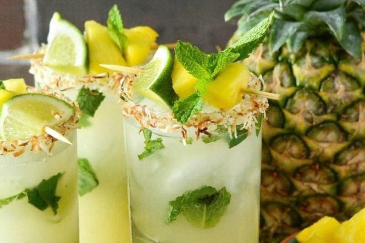 A pineapple mojito with lime and mint garnishes, perfect for St. Patrick's drinks.