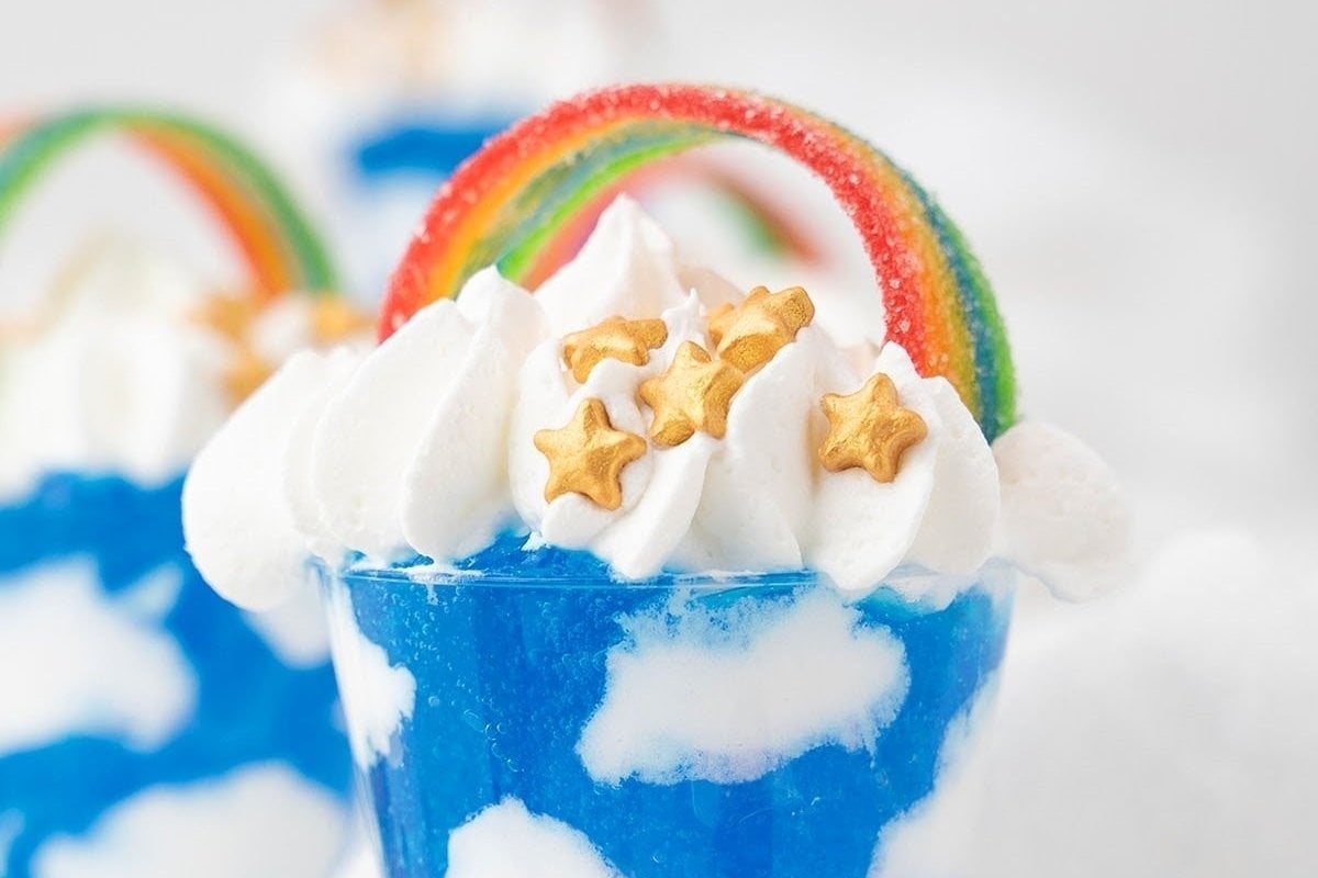 A blue dessert topped with whipped cream and rainbow candy is a delightful treat! Explore rainbow recipes to create this colorful indulgence.