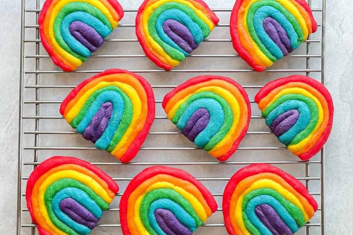 Rainbow colored cookies on a cooling rack, perfect for rainbow recipes.