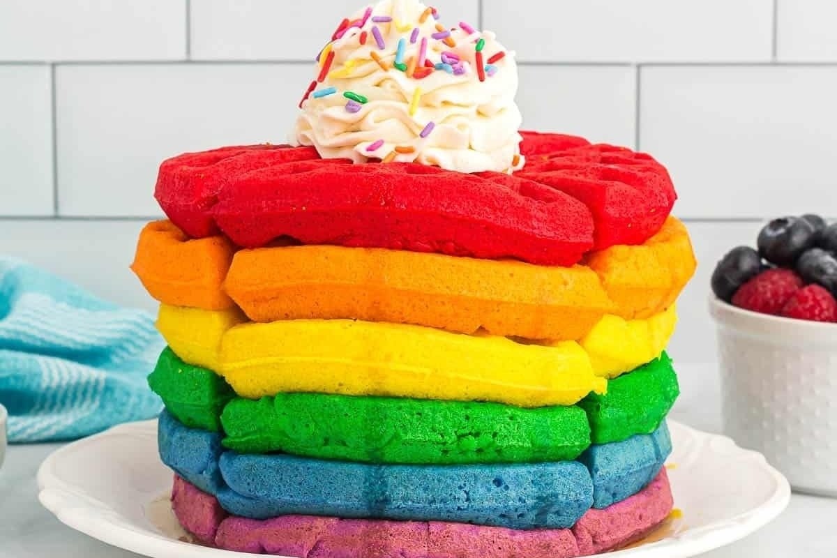 A stack of rainbow pancakes on a plate, perfect for those who are looking for colorful recipes.