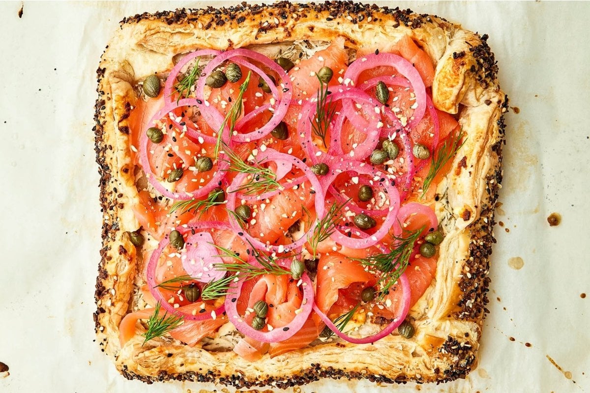 A tart with smoked salmon and onions on top for a girl's dinner.