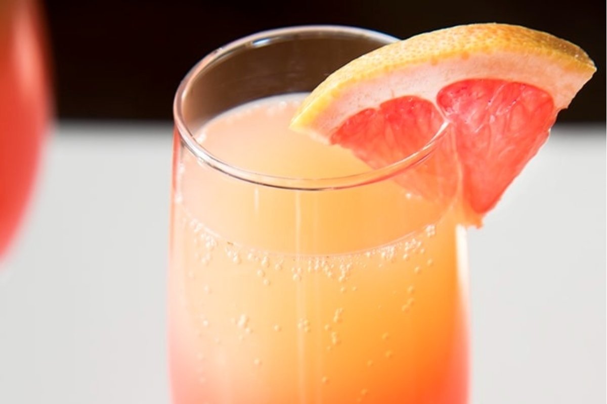 A glass of champagne with a slice of grapefruit, perfect for St. Patrick's drinks.