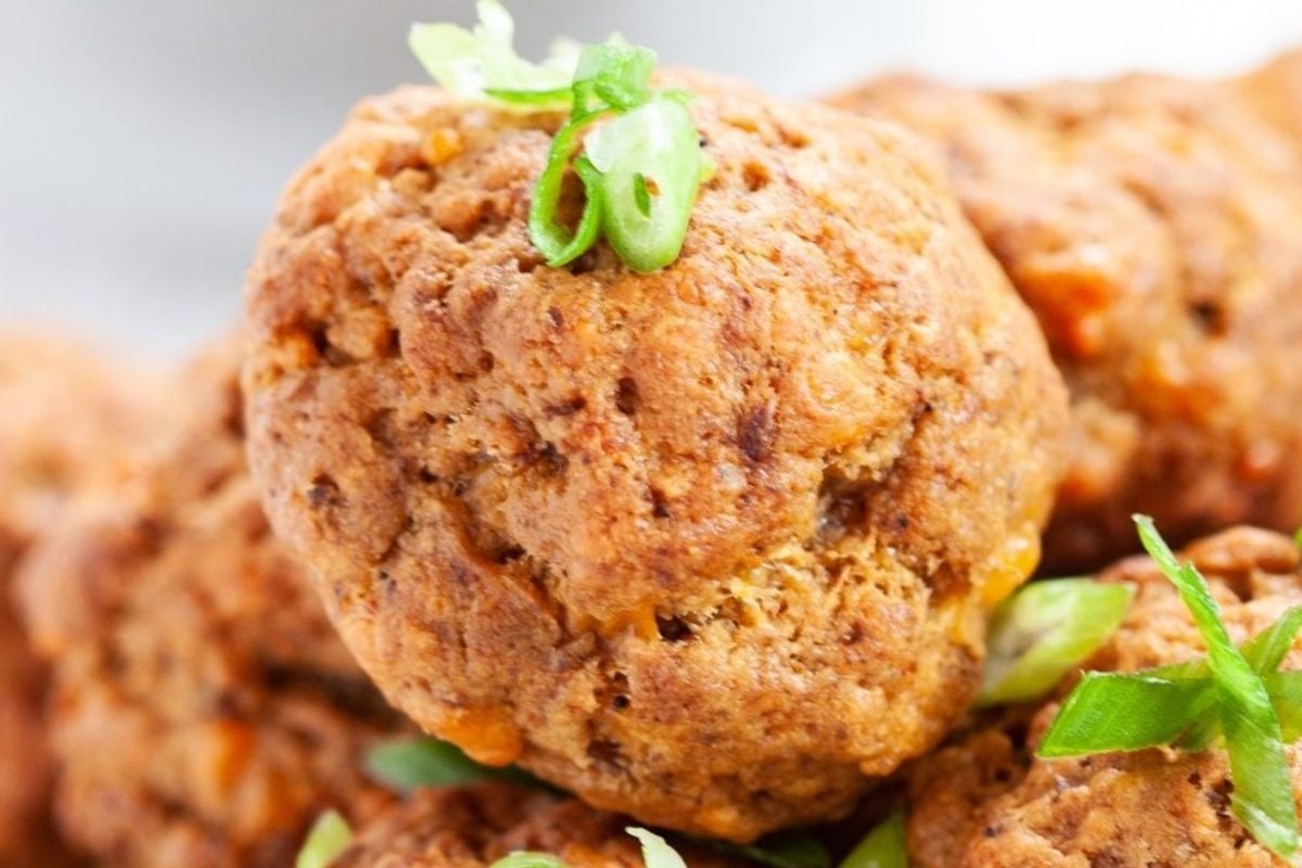 Close-up of golden-brown, bite-size falafel balls garnished with sliced green onions—perfect for a game day snack.