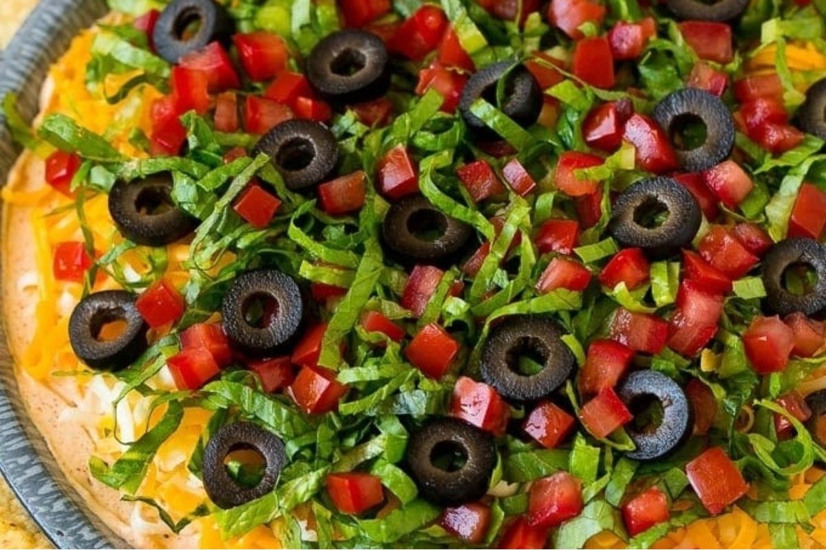 A pizza with taco-flavored black olives, tomatoes, and green peppers.