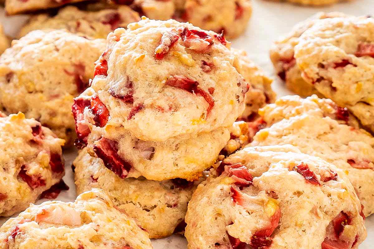 Close-up of freshly baked strawberry biscuits, golden brown with visible chunks of strawberries throughout—perfect as delightful Valentine's Day cookies.