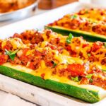 A tray of taco zucchini boats filled with meat and cheese.
