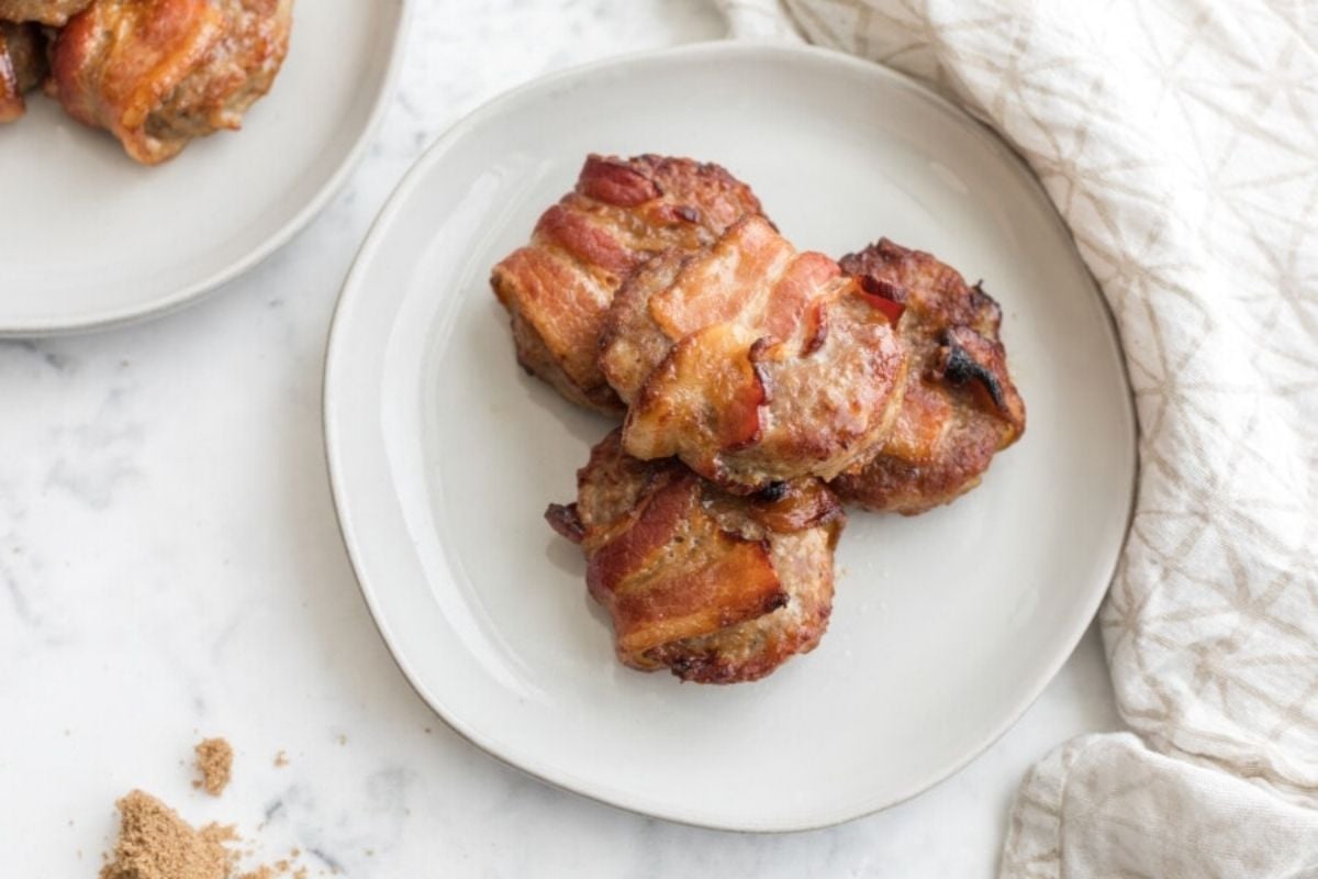 Bacon-wrapped chicken thighs served on a white plate for Father's Day breakfast.