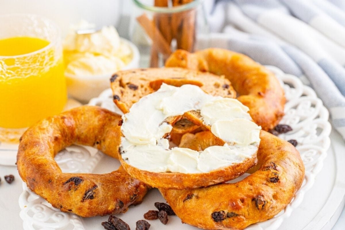 A Father's Day breakfast setup featuring raisin bagels with cream cheese and a glass of orange juice.