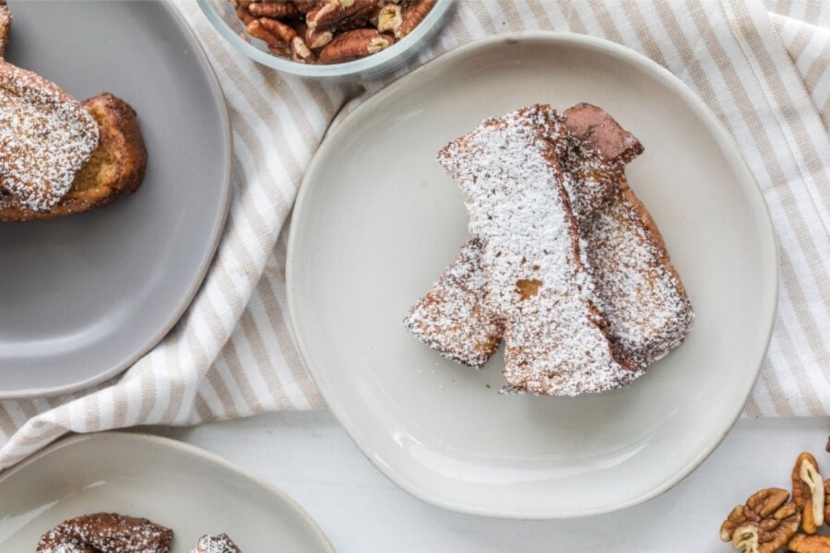 French toast with powdered sugar served on a plate with pecans on the side for Father's Day breakfast.